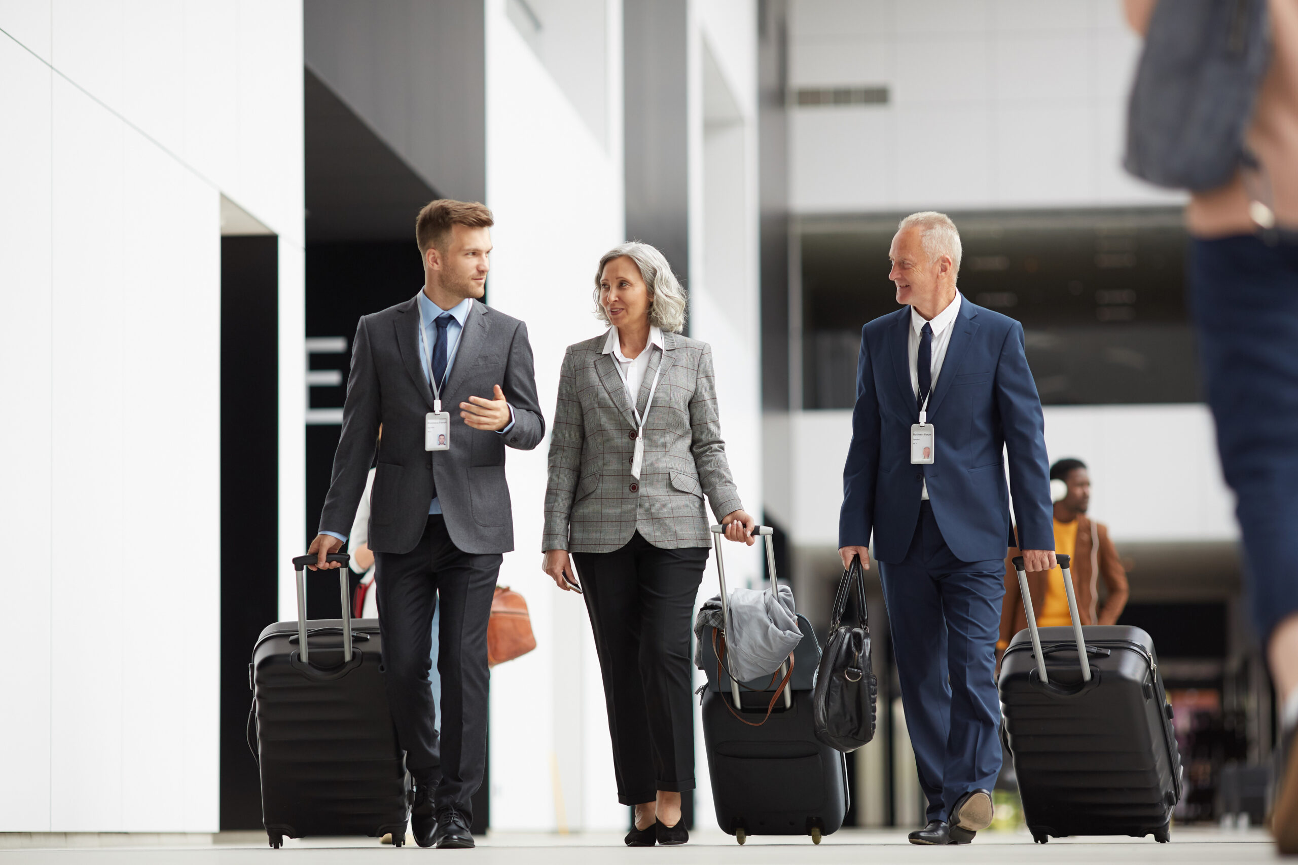 Business professionals walking with luggage in airport